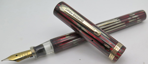 ITEM #3452: DIAMOND POINT FOUNTAIN PEN IN RED/GREY MARBLED VERTICAL STRIPES. GOLD FILLED TRIM. "NEW DIAMOND POINT PEN COMANY" NIB IN FINE. EXTREMELY CLEAR INK VIEW SECTION.