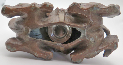 ITEM #6656: METAL CAMEL INKEWLL WITH GLASS INCERT. HILIGHTS HAND PAINTED IN RED. ORNATE DETAIL. 4" tall x 5" length x 2.5 width. 