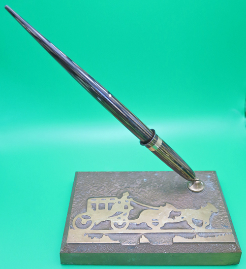 ITEM #6664: SHEAFFER BRASS STAGE COACH DESK SET WITH FOUNTAIN PEN. STRIATED GOLD/BROWN VACUMATIC FILLING PEN WITH BROAD NIB. MATCHING STRIATED DESK SOCKET.