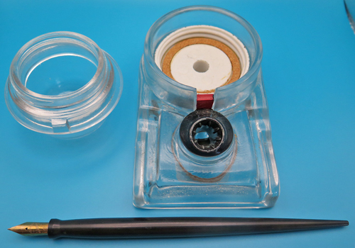ITEM #6665: SENGBUSCH CLEAR GLASS HANDIPEN DESK SET. FOUNTAIN PEN HAS EXTRA FIN NIB. NEW OLD STOCK IN ORIGINAL RED PACKAGING. CONTAINS DIRECTIONS. CIRCA 1920.