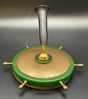 ITEM #6846: NAUTICAL THEMED SHIP WHEEL DESK BASE. GREEN STONE BASE WITH METAL TOP AND BRASS HANDELS. BLACK PEN HOLDER WITH BRASS SOCKET. UNKNOWN MAKER. DIMENSIONS ARE 4 x 2 3/4 x 4 INCHES